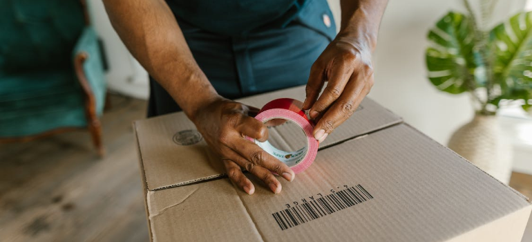 A worker duct taping a box